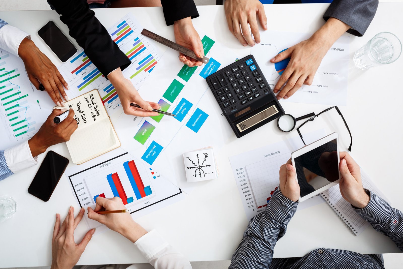 Picture of businessmen's hands on white table with documents, coffee and drafts