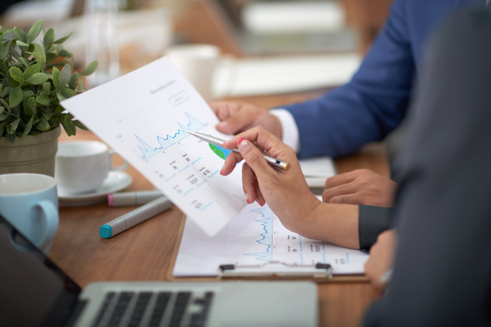 hands-man-woman-business-attire-sitting-desk-office-discussing-graph